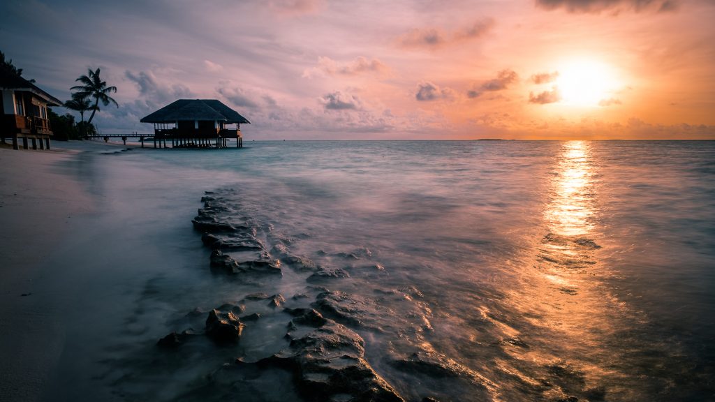Sunset over the ocean at one of the beaches in Maldives during the dry season; the best time to visit Maldives for warm weather.