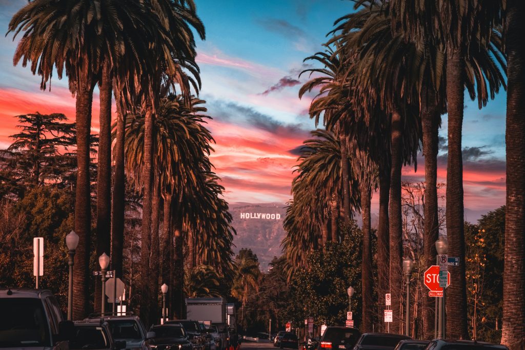 Wide shot of Hollywood Boulevard in Los Angeles with the Hollywood sign in the background.