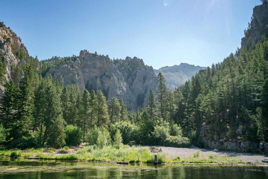 Tall trees and mountains surrounding Canyon Ferry Lake in Montana during July.