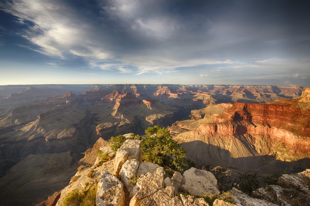 Wide shot of the South Rim of the Grand Canyon with clouds in the sky during July.