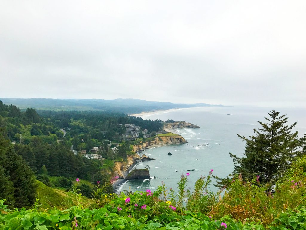 Greenery with colorful flora against the coastline along the Oregon Coast; one of the best places to visit in July USA.