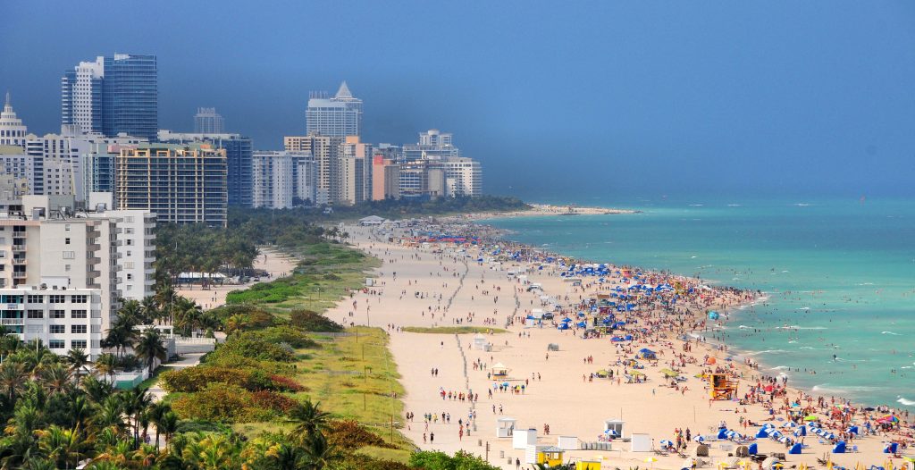 Wide shot of South Beach in Florida during July with people lounging by the beach.