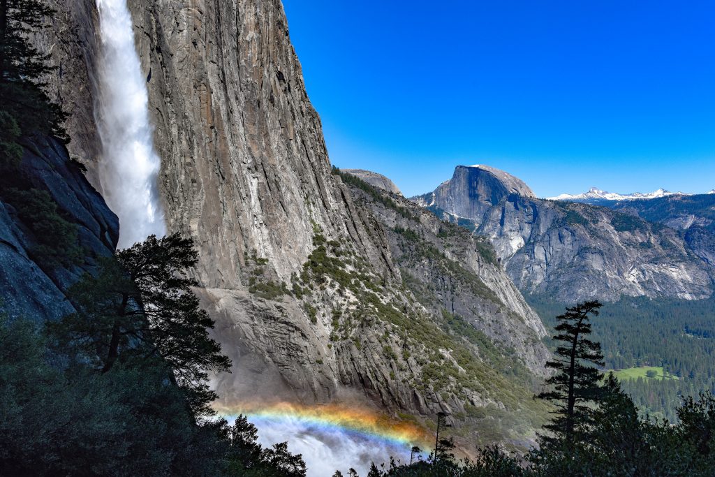 Yosemite Falls with a small rainbow over the water at Yosemite National Park, California during July.