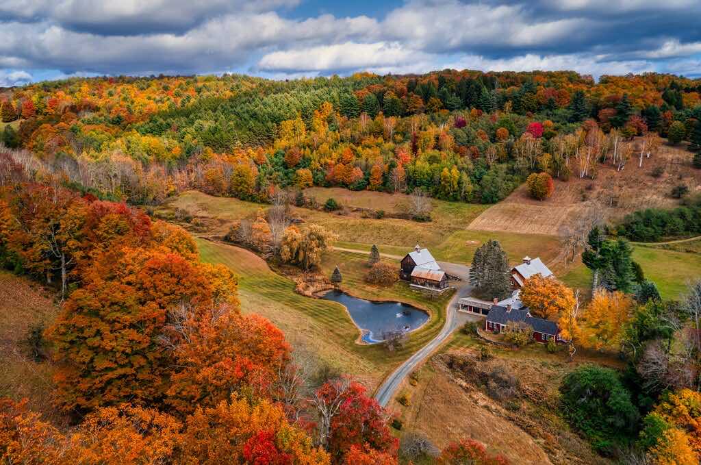 a barn nestled in a valley during fall, places to visit in September in USA