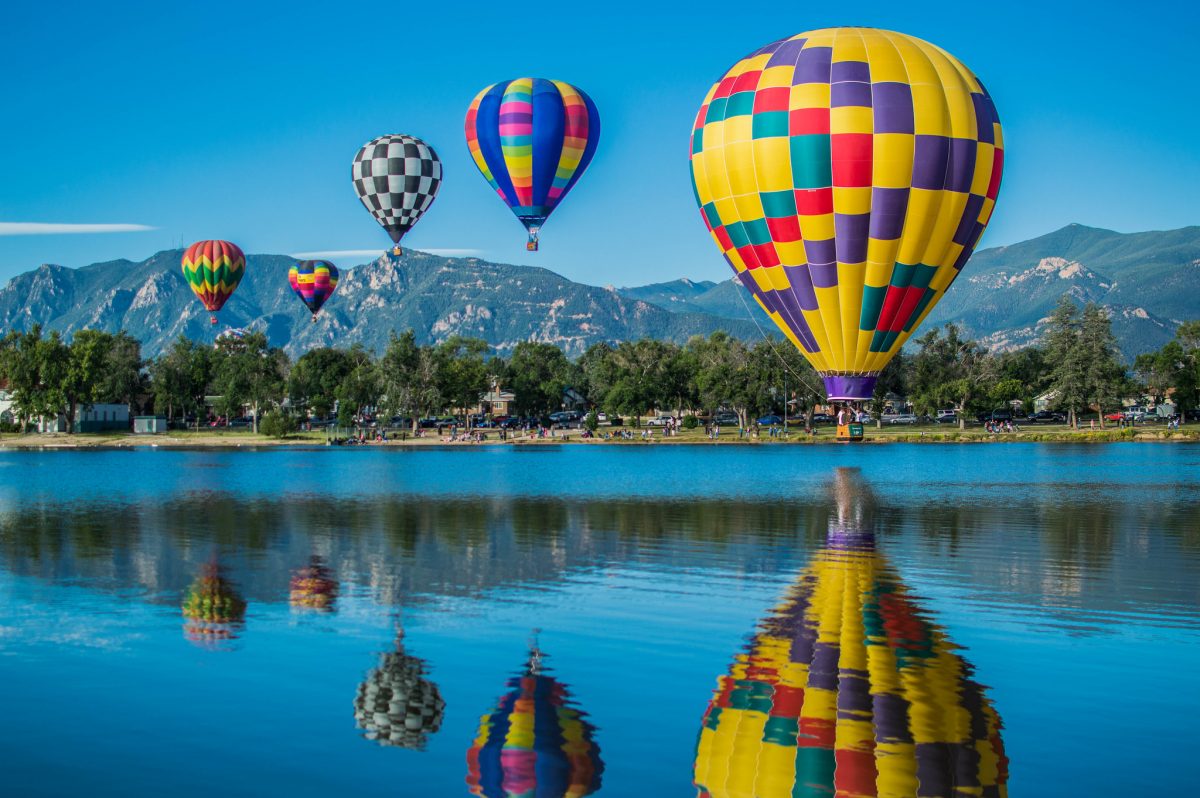 Colorful hot air balloons touching down at Colorado Springs.