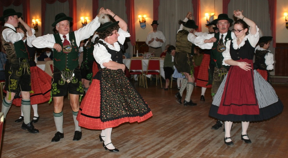 Men and women dancing during the while wearing traditional German outfits; Oktoberfest near me in Rhode Island.