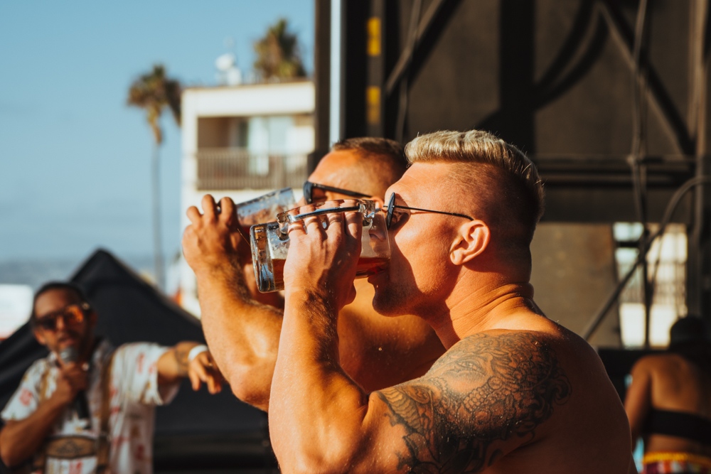 Men chugging beer during the OB Oktoberfest in San Diego.
