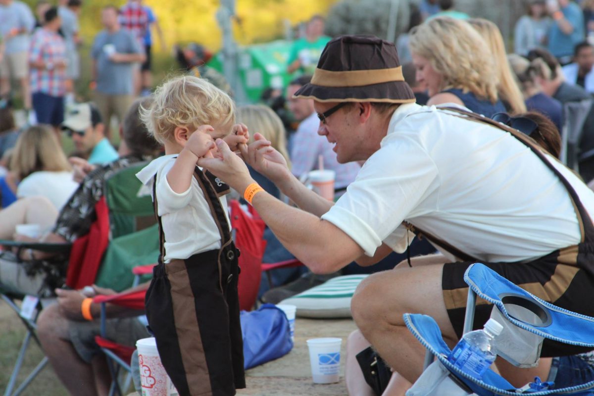 Father and son wearing matching lederhosen; Oktoberfest near me in Texas