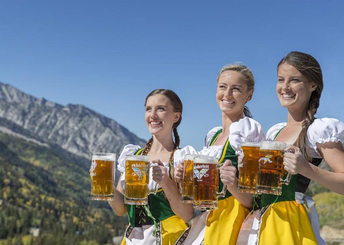 Women dressed in German barmaid outfits holding pints of beer during Oktoberfest, one of the festivals in Salt Lake City during the fall months.