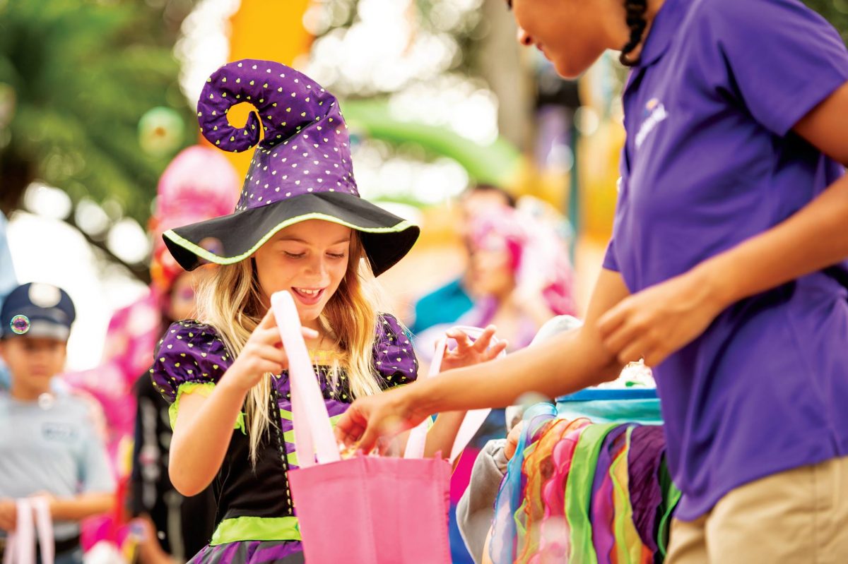 Little girl dressed in a witch’s costume trick-or-treating at SeaWorld San Diego, one of the 15 fun things to do in the fall.