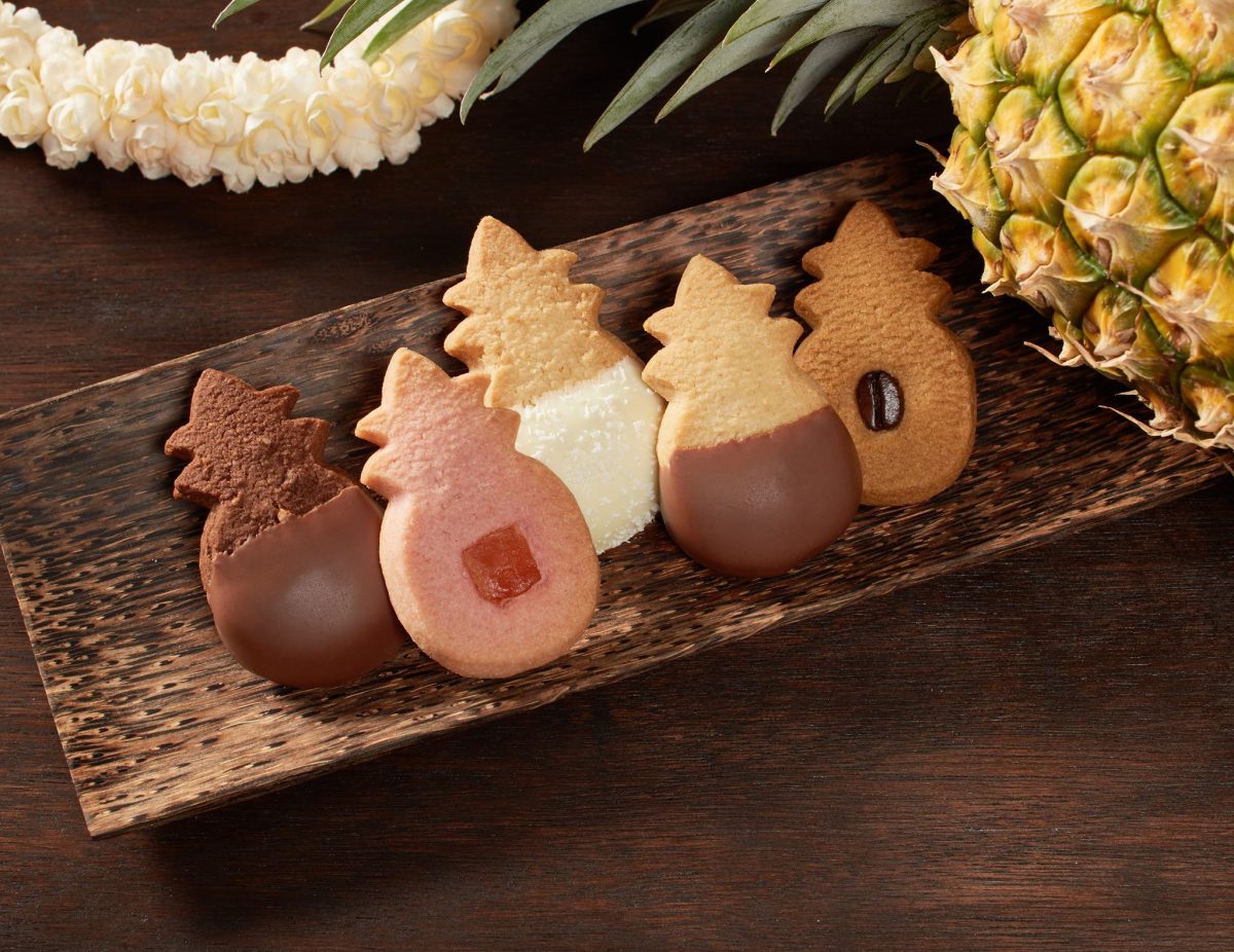 assortment of shortbread cookies in different flavors on a wooden serving plate.
