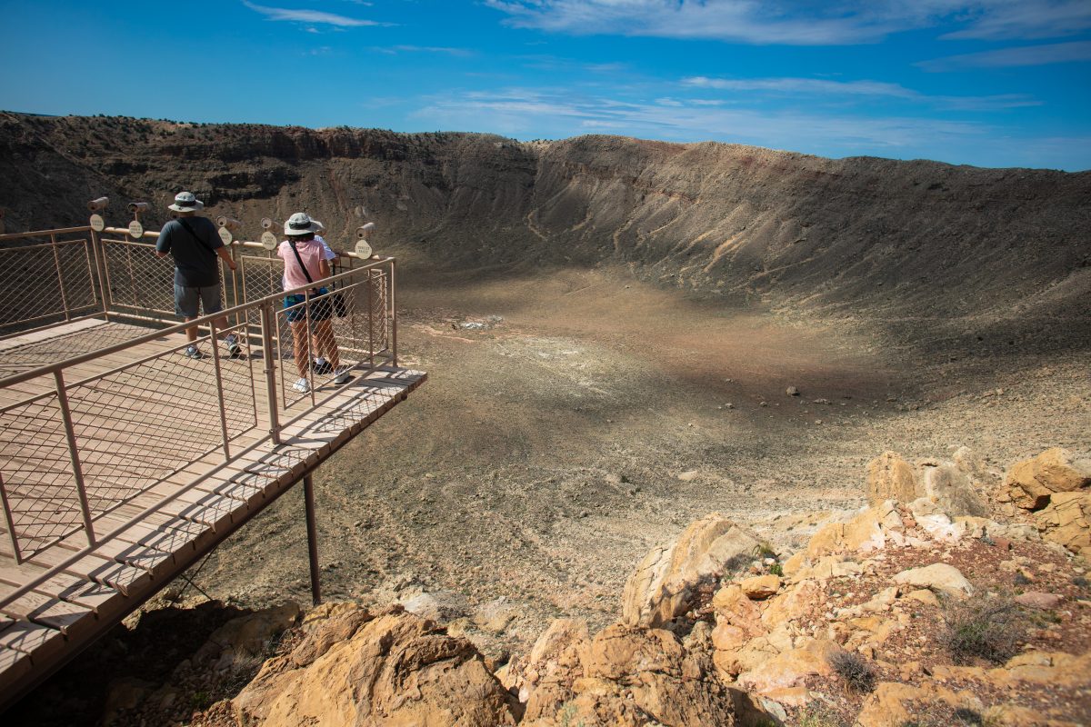 Couple marveling at the Meteor Crater from an observation deck, one of the best things to do near Flagstaff. 