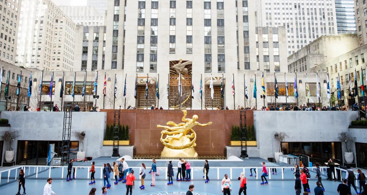 people on rollerblades skating on the rink in front of rockefeller plaza at the rockefeller center in new york city.