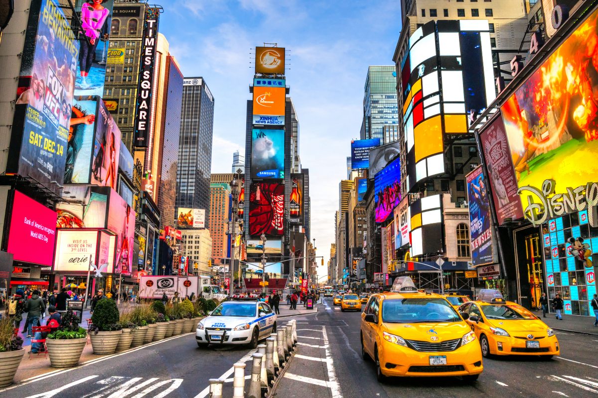 cars and crowds at times square with colorful electronic billboards. 