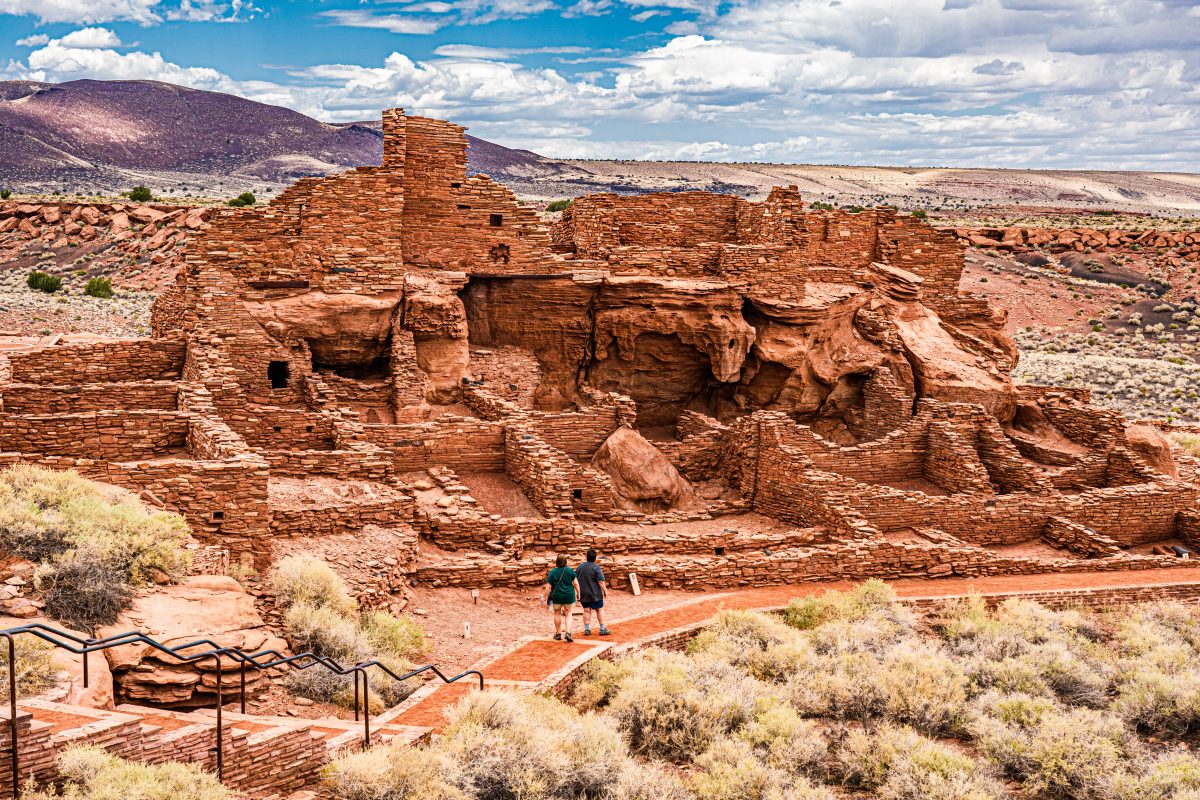 Couple visiting the pueblo ruins at the Wupatki National Monument, one of the top things to do in Flagstaff, AZ.