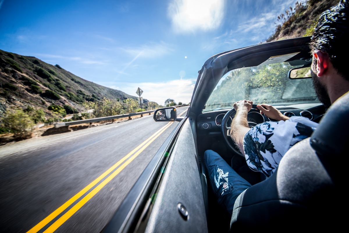 A Tourist's Guide to Driving in California and the USA Man driving his sport car - A Tourist's Guide to Driving in California and the USA