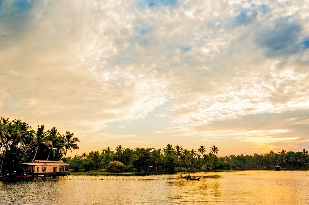 two men fishing in the Kollam backwaters near Alappuzha at sunset.