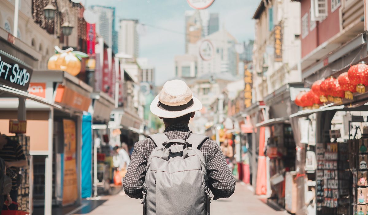 Young man hipster traveling with backpack and hat