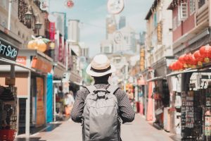 Young man hipster traveling with backpack and hat