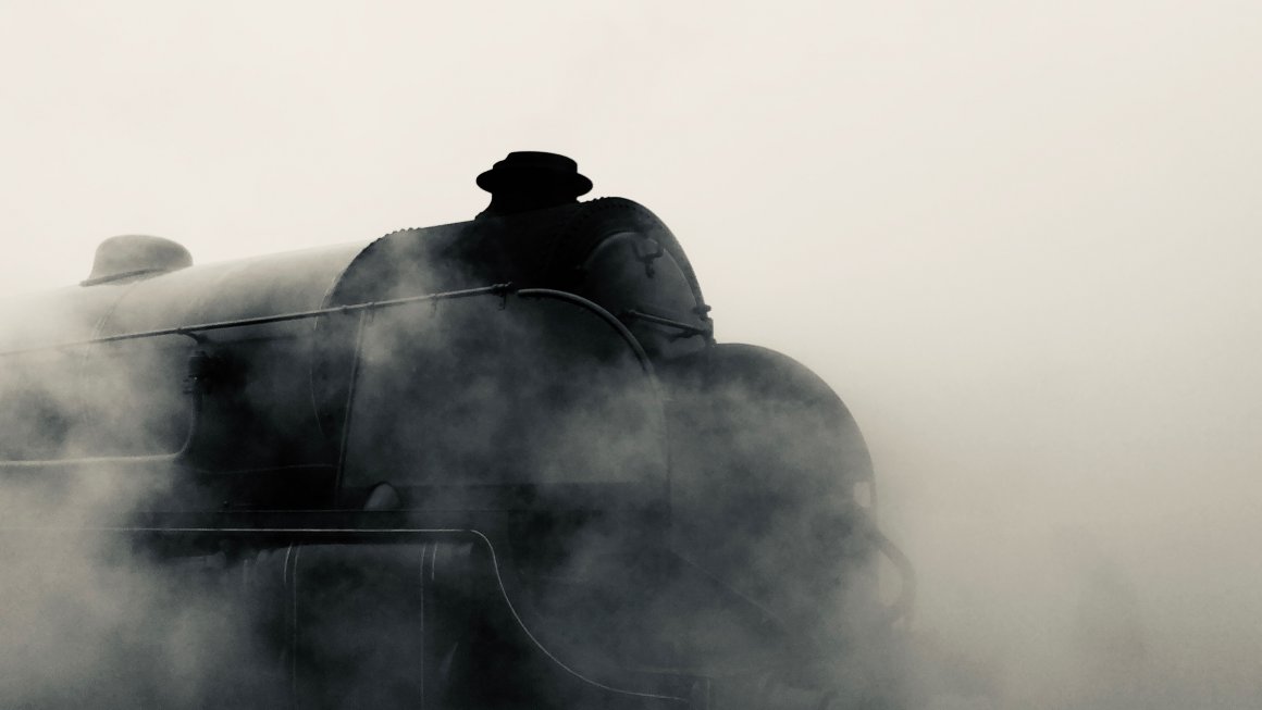 Steam Train Photo of a black steam train with the whole background and foreground covered in grayish white mist and smoke