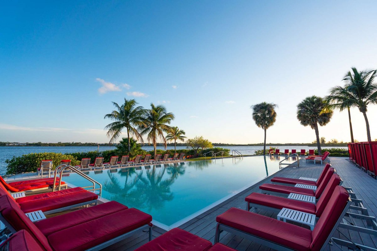 Red lounge chairs surround the pool overlooking St. Lucie River in Club Med Sandpiper Bay, Port St. Lucie. Florida