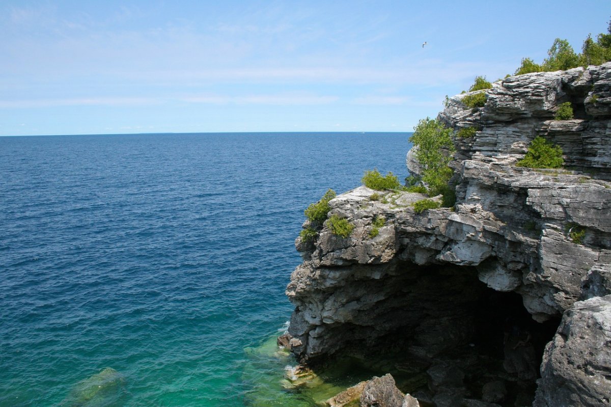 Exposed rocks peppered with lush vegetation stand on the coastline of the Georgian Bay in Ontario, Canada