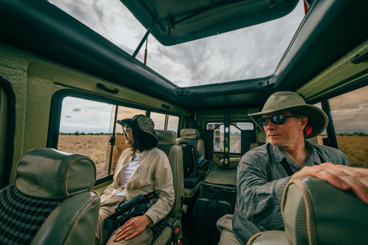 A man and a woman sitting inside a safari jeep