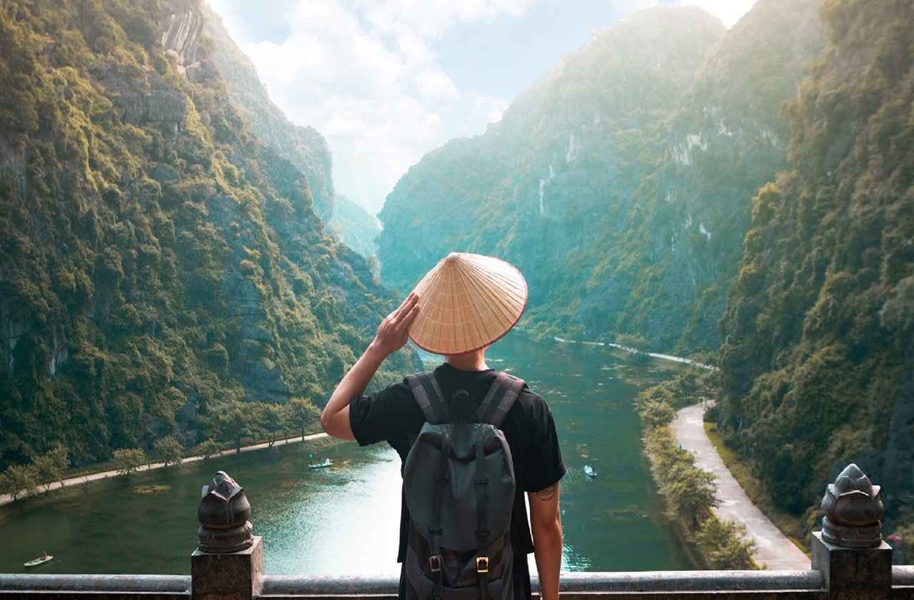 Man with traditional hat overlooking Ninh Bình