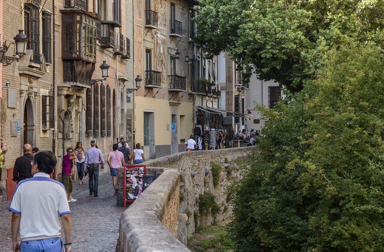 Tourists walking along Granada's Carrera del Darro