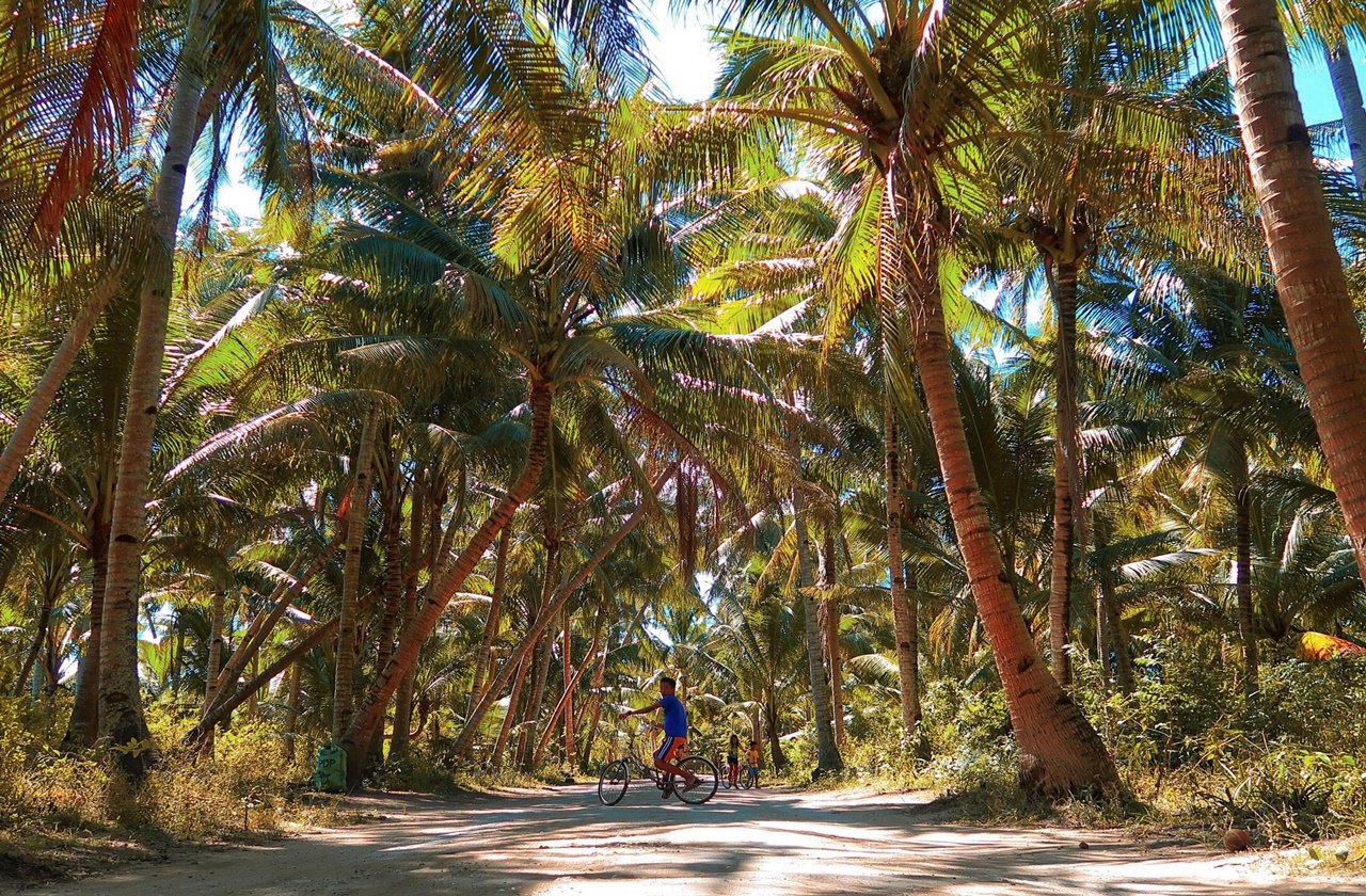 Boy biking in the middle of a street in bantayan island