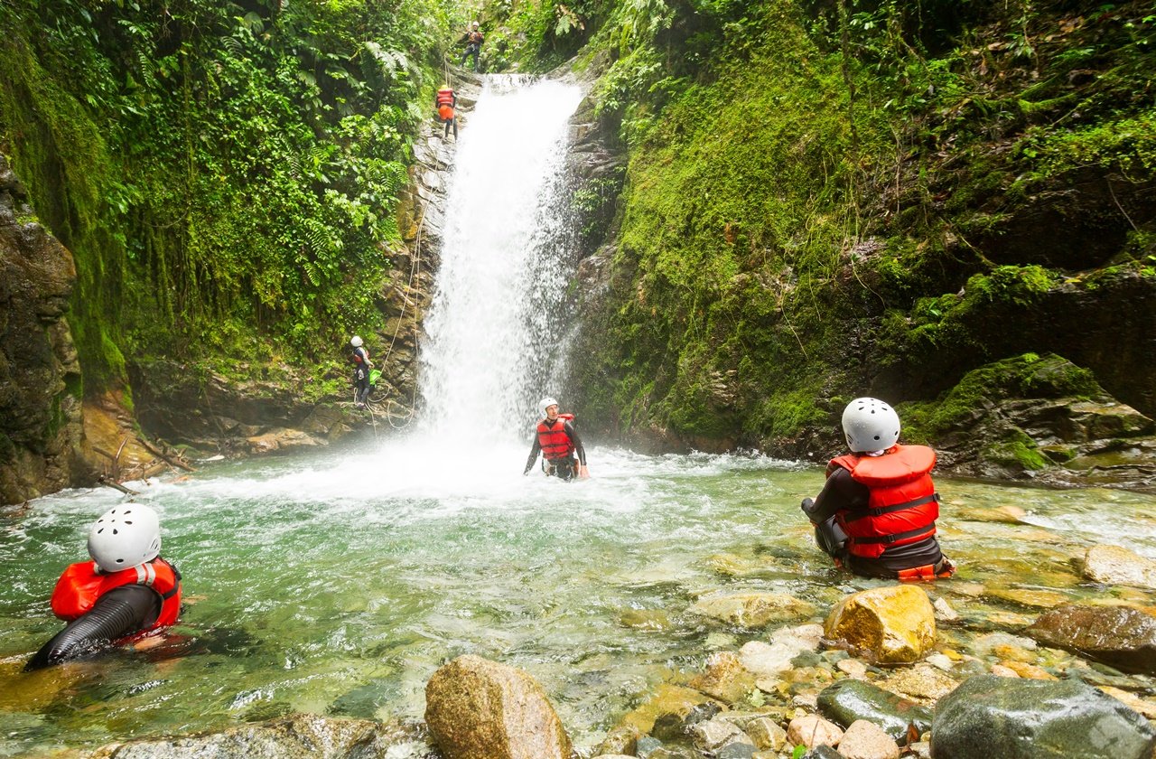 Waterfall canyoning Group of canyoners resting at a waterfall
