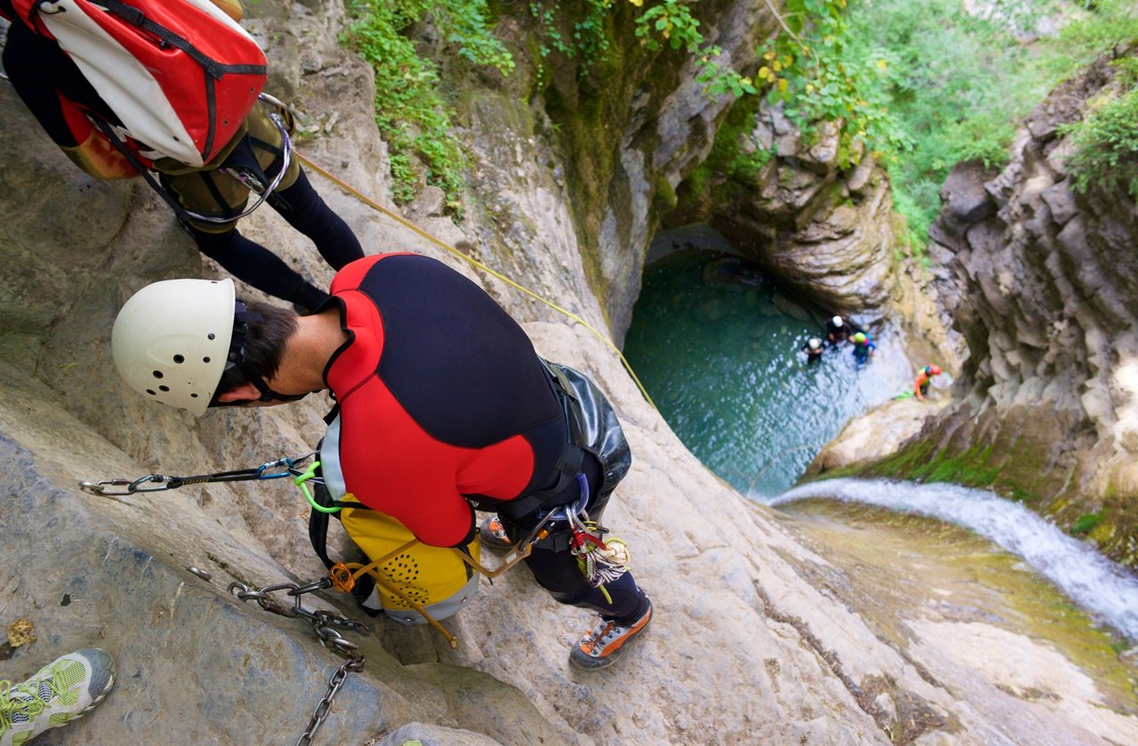 Rappelling Man going down to a pool of water
