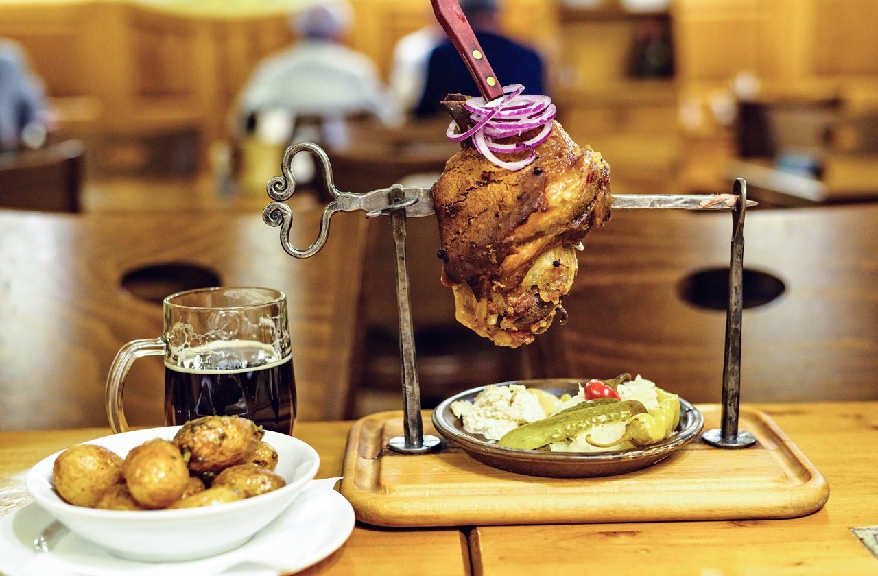 Prague pork knuckle Baked pork knuckle with vegetables, potatoes and beer