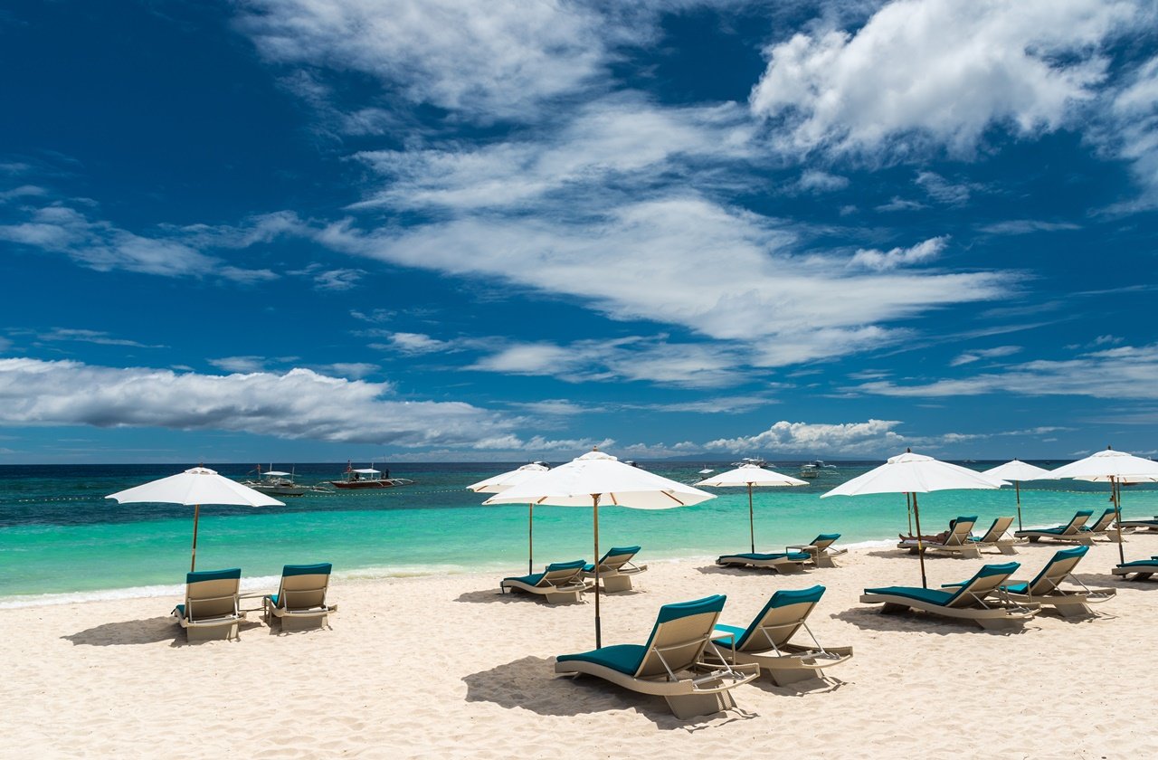 Bohol beach Sunbeds at beach umbrellas at a resort in Bohol