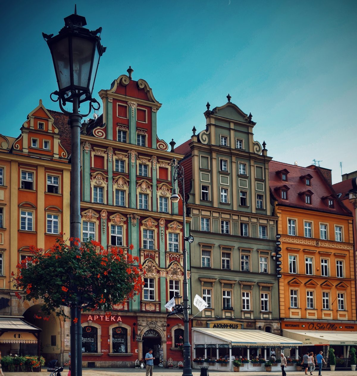Wroclaw, Poland People walking in front of multicolored buildings in Wroclaw, Poland
