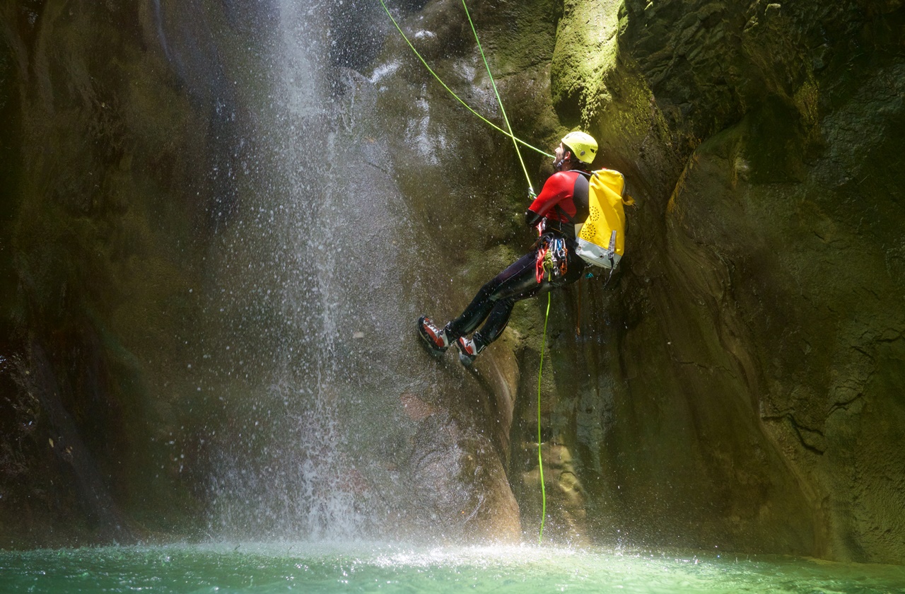 Canyoning activity Man abseiling to a pool of water in Spain